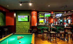 Et billardbord i en bar med flere tv-skærme, der viser sport. (AI-genereret tekst)