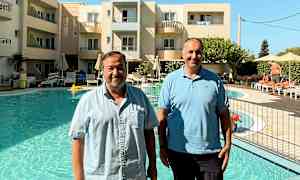 Personer står ved poolen foran et hotel. (AI-genereret tekst)