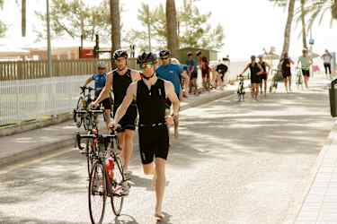 Gruppe løber med deres cykler på triatlonrejse