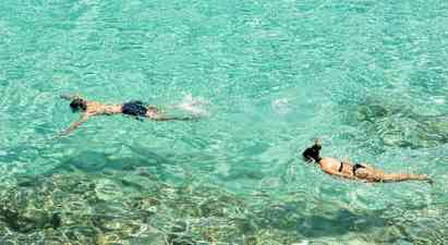 To personer snorkler i klart turkis vand. (AI-genereret tekst)