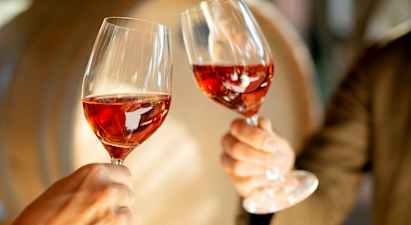 To glas med rosévin løftes op. (AI-genereret tekst)