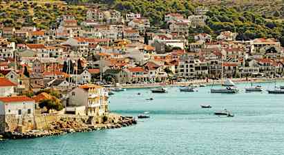 En kystby med huse tæt på vandkanten og både i bugten. (AI-genereret tekst)