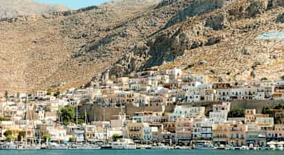 En kystby med små huse på en bjergskråning. (AI-genereret tekst)