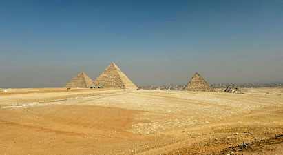 Billedet viser de store pyramider i Giza omgivet af ørkenlandskab. (AI-genereret tekst)