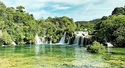 Et naturskønt vandfald omgivet af frodig vegetation. (AI-genereret tekst)