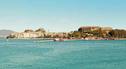 En by ved havet med historiske bygninger og en fæstning på en bakke. (AI-genereret tekst)