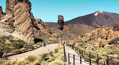 En klippeformation med gangsti og bjerge i baggrunden. (AI-genereret tekst)