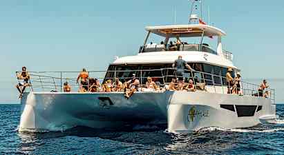 En hvid motorbåd på havet med mennesker der nyder solen. (AI-genereret tekst)