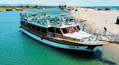 En båd ligger ved en kaj nær stranden. (AI-genereret tekst)