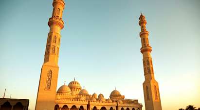 En stor moské med to høje minareter og kupler. (AI-genereret tekst)