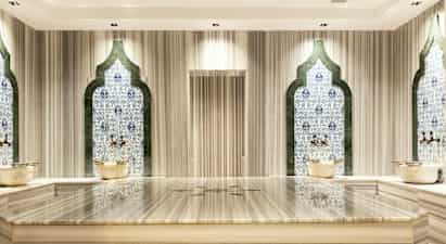 Hamam-rum med mosaikvægge og marmorbænk. (AI-genereret tekst)