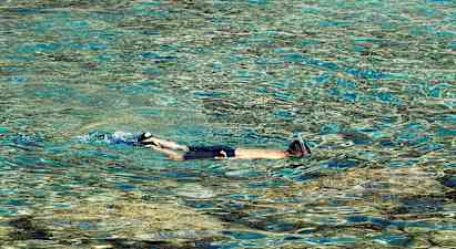 Person med snorkel svømmer i klart vand. (AI-genereret tekst)