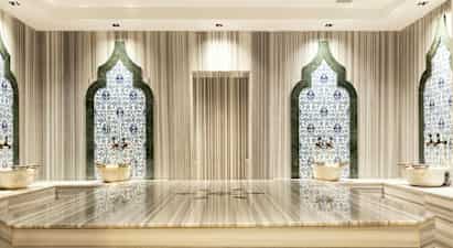 Hamam-rum med mosaikvægge og marmorbænk. (AI-genereret tekst)