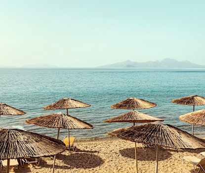 Stranden neden for hotellet. Liggestolene blev skiftet ud sommeren 2025 og ser derfor anderledes ud end på billederne.