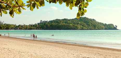 En sandstrand med mennesker, havet og en skovklædt ø i baggrunden. (AI-genereret tekst)
