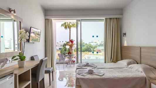 Hotelværelse med to enkeltsenge, skrivebord og balkon med siddepladser. (AI-genereret tekst)