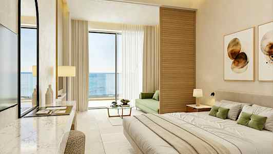 Et moderne hotelværelse med havudsigt, møbleret med en stor seng, en grøn sofa og en altan. (AI-genereret tekst)