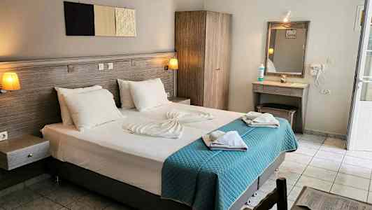 Hotelværelse med en dobbeltseng, garderobe, sminkebord og lyse tekstiler. (AI-genereret tekst)