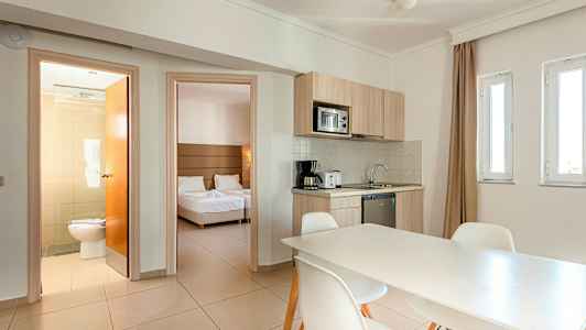 Et rum med køkken og spisebord, soveværelse og badeværelse. (AI-genereret tekst)