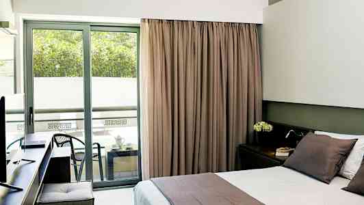 Hotelværelse med dobbeltseng og balkon med siddeplads. (AI-genereret tekst)