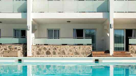 Eksteriør af bygning med pool foran. (AI-genereret tekst)