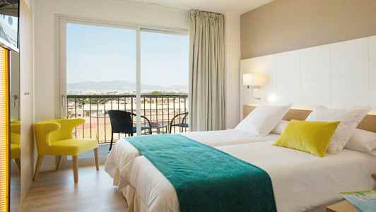 Et hotelværelse med to senge, en stol og en altan med udsigt. (AI-genereret tekst)