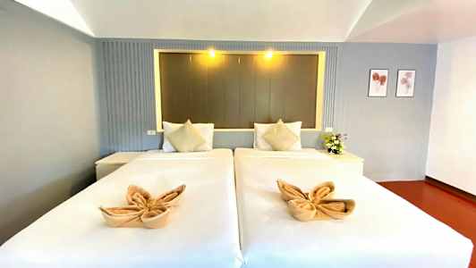 To enkeltsenge med dekorerede håndklæder og puder, beliggende i et stilfuldt rum. (AI-genereret tekst)