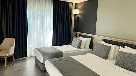 Indretning af hotelværelse med to senge og moderne design. (AI-genereret tekst)