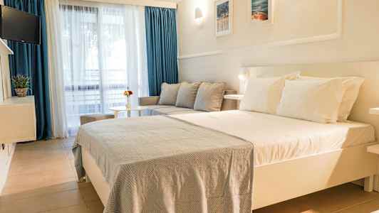 Et hotelværelse med en stor seng, sofa og bord. (AI-genereret tekst)