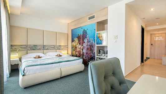 Billede af et hotelværelse med dobbeltseng, havinspireret dekoration bag sengen og skrivebord med stol. (AI-genereret tekst)