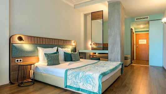 Et hotelværelse med en dobbeltseng, træ- og tekstilelementer, lyse vægge og træindretning. (AI-genereret tekst)