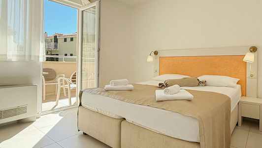 Værelse med dobbeltseng og udsigt til balkon. (AI-genereret tekst)