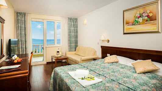 Billede af hotelværelse med udsigt til havet gennem et vindue. (AI-genereret tekst)