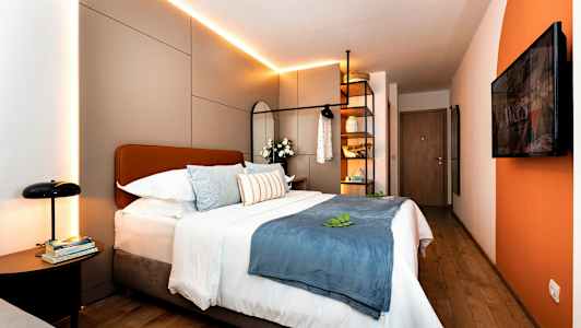 Moderne hotelværelse med dobbeltseng, dekorative puder og belysning. (AI-genereret tekst)