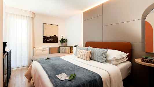 Et moderne hotelværelse med en stor seng, puder og indretningsdetaljer. (AI-genereret tekst)