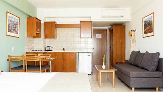 Et hotelstudie med køkken, spisebord og siddeområde. (AI-genereret tekst)