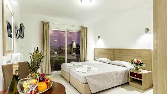 Billede af et hotelværelse med to enkeltsenge, et bord med frugt og drikke samt en altan med udsigt. (AI-genereret tekst)