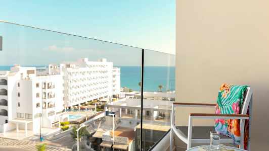 En altan med udsigt til havet og omkringliggende bygninger. (AI-genereret tekst)