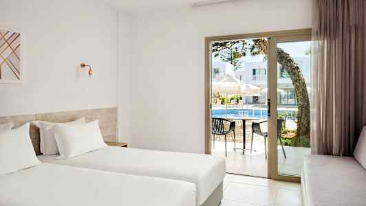 Hotelværelse med to enkeltsenge, udsigt til en pool gennem glasdøre. (AI-genereret tekst)