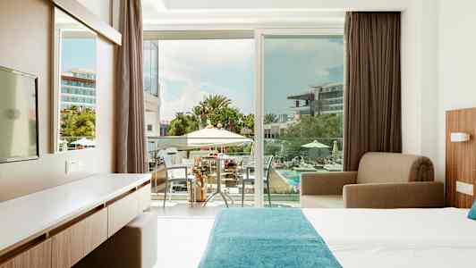 Hotelværelse med udsigt over poolområdet. (AI-genereret tekst)