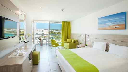 Moderne hotelværelse med grønt interiør og udsigt over altan og omgivelser. (AI-genereret tekst)