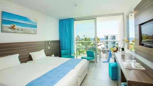 Moderne hotelværelse med dobbeltsenge, havudsigt og blå indretning. (AI-genereret tekst)