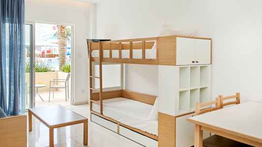 Billede af et rum med køjeseng, et bord og stole, samt en terrasse med siddepladser. (AI-genereret tekst)