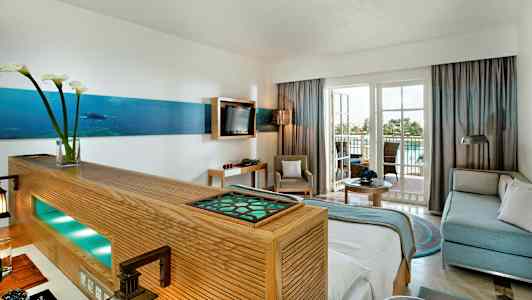 Indretning af et lyst hotelværelse med siddeområde og altan. (AI-genereret tekst)