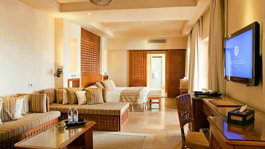 Pladsfuldt hotelværelse med moderne indretning i neutrale farver. (AI-genereret tekst)