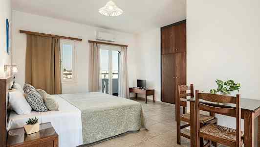 Et soveværelse med en dobbeltseng, et lille bord med to stole og et skab. (AI-genereret tekst)