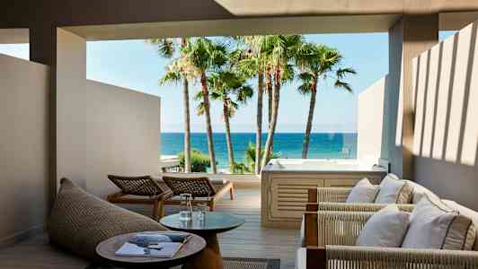 Udendørsområde med siddepladser, bord og jacuzzi med havudsigt. (AI-genereret tekst)