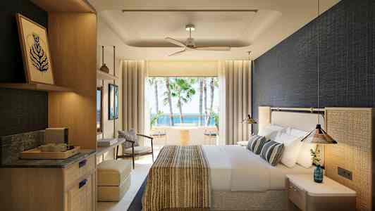 Et hotelværelse med lys indretning og udsigt over palmer og hav. (AI-genereret tekst)