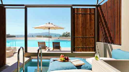 Liggestole ved en pool med parasol og snacks på en dagseng. (AI-genereret tekst)