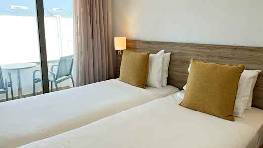 Billede af et hotelværelse med to enkeltsenge og altan. (AI-genereret tekst)